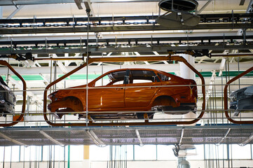 Car body transported by hanging conveyor in plant workshop