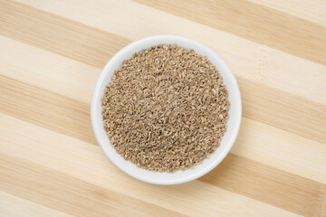 Top view of carom seeds on wooden background, ajwain