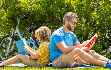 Father and son immersed in outdoor reading adventure. the joy of family reading. special moment for father and son. Father and son reading time. Father and son bonding through outdoor reading