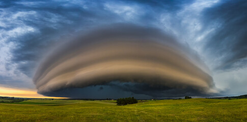 Angry supercell storm influenced by Climate change. Dangerous storm supercell shelf cloud with layers. - obrazy, fototapety, plakaty