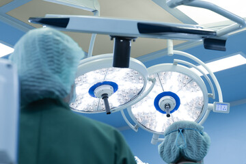 Surgery modern operating room with surgical lamp for emergency save lives.Medical team of surgeons working surgical intervention.Selective focus.