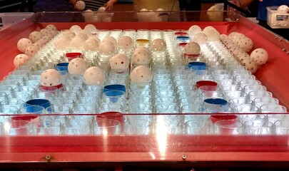 Midway game of chance - land the whiffle ball in a colored glass to win a prize