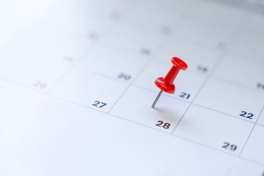 Selective focus. Photo picture of a calendar with a red pin on the 28th.