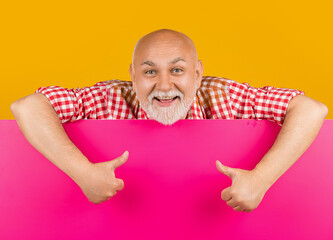 happy senior man with copy space on blank banner. thumb up