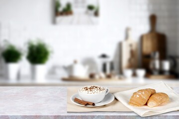 Cup of hot coffee and fresh croissant