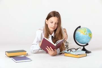 education and school concept - little student girl studying geography with globe and book