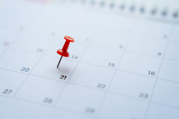 Close-up view of red pins with calendar for meeting reminders and appointments.