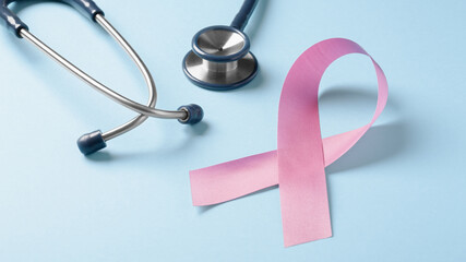 Pink ribbon with stethoscope on blue background, breast cancer awareness month