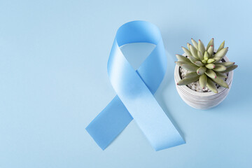 Blue ribbon on light blue background with copy space, cancer awareness, world diabetes day