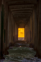 Fototapeta na wymiar Sunset through the pier at the La Jolla beach
