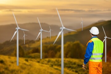 Young engineer man posing wind turbine background