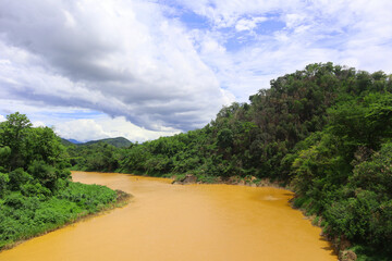 Obraz premium View of the river in the rainy season flows through the forest and mountains.