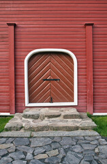closed doorway on red painted wooden wall outdoors