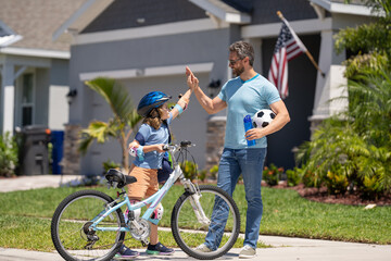 Obraz premium dad and son enjoying a ride together. Supportive father guiding son kid first bike ride. Father and son sharing biking adventure. father and son navigate the path together. creating memories