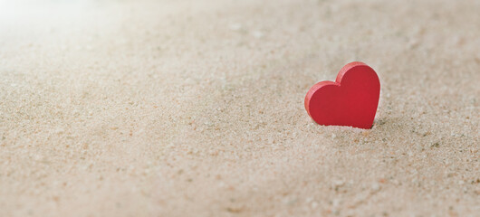 One Wooden Red Hearts On a sandy beach With a Sunlight, The Concept of Love and Couple. Valentine's Day Concept.