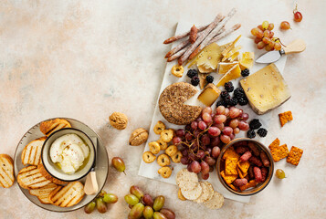 Cheese plate with grapes, blackberries, and nuts. Delicious appetizers. Top view, flat lay.