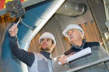 worker tightening bolt with socket on industrial site