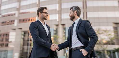 happy two businessmen in suit deal with handshake. photo of two businessmen deal with handshake - obrazy, fototapety, plakaty