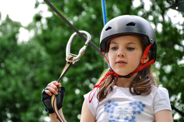 Fototapeta na wymiar adventure climbing high wire park - people on course in mountain helmet and safety equipment.