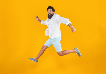 Fototapeta na wymiar surprised bearded guy hurry on background. photo of bearded guy in a hurry wearing summer fashion
