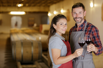 wine loving couple tasting wines in winery cellar