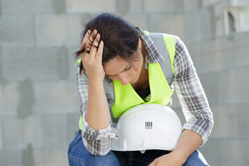 depressed female builder with her head in her hands