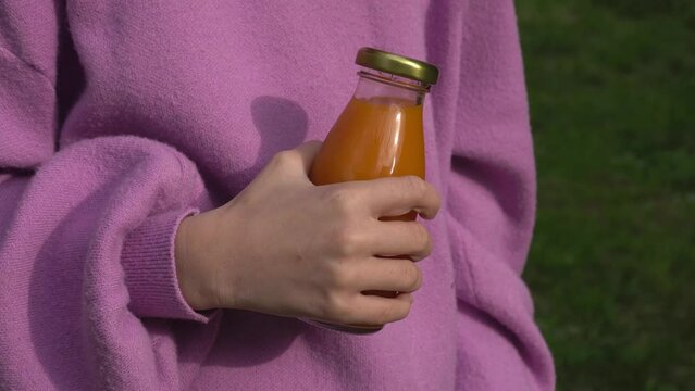 Girl opens a bottle of juice
