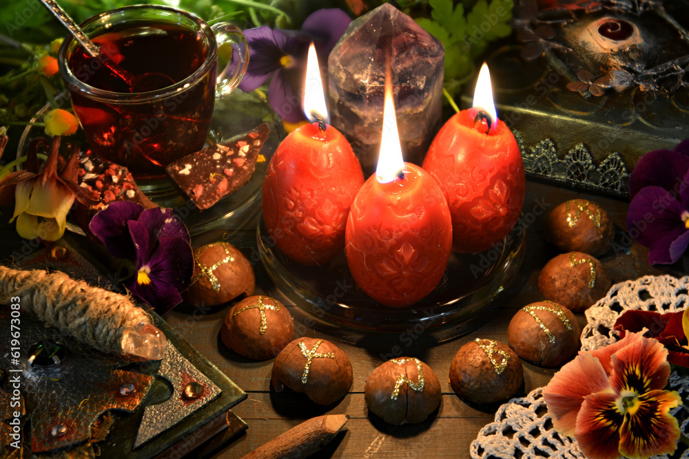 Poster still life with red candles, runes, magic wand and book of spells on ritual table. occult, esoteric 