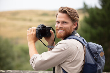 male photographer using camera in the countryside