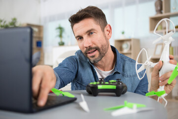 man fixing propeller of drone with screw driver at workshop