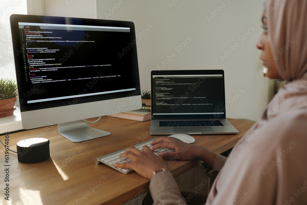 Aufkleber Focus on hands of young Muslim female programmer decoding data or developing new software while sitting in front of computer screen
