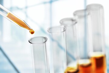 Dripping liquid from glass pipette in laboratory,