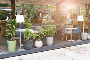 Summer street cafe interior in green city park, ornate with flowers and decorative elements, cozy place for outdoor coffee or diner