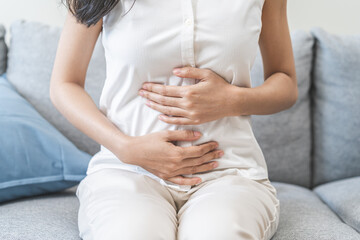Flatulence ulcer, asian young woman, girl hands in belly, stomach pain from food poisoning, abdominal pain and digestive problem, gastritis or diarrhoea. Abdomen inflammation, menstrual period people. - obrazy, fototapety, plakaty
