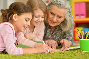 Fototapeta premium grandmother and granddaughters doing homework, together