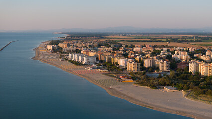 Fototapeta na wymiar aerial shot of sandy beach with umbrellas and town background
