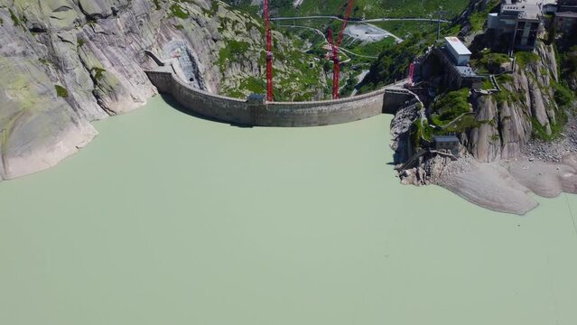 Aerial drone backward moving shot over Hotel Grimsel Hospiz in Grimsel Pass, Swiss Mountain, Switzerland on a sunny day.