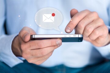 Human hand using modern smartphone with email icon