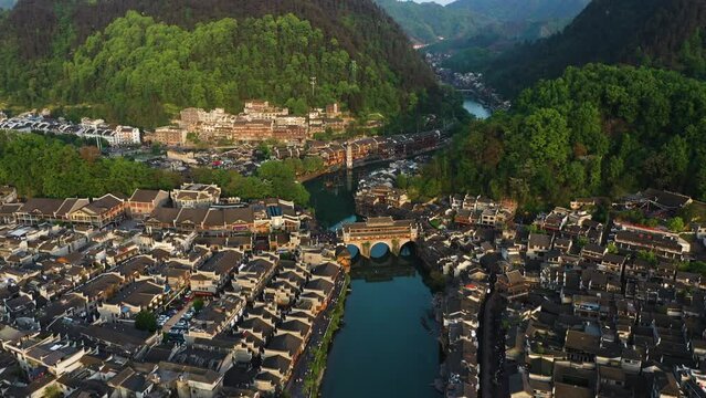Aerial view tilting over the Phoenix Hong Bridge, golden hour in Fenghuang County, China