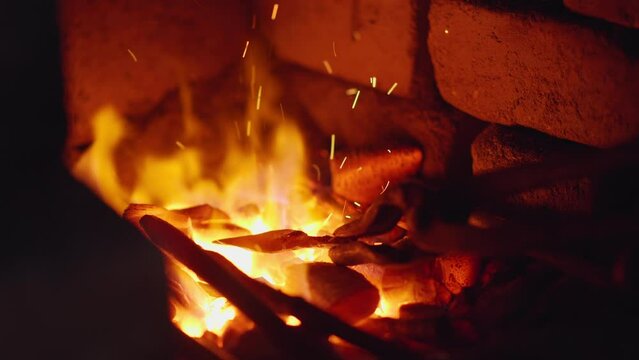 Blacksmith placing hot arrowhead into forge