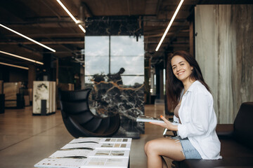 a woman looks at a catalog of goods in a hardware store