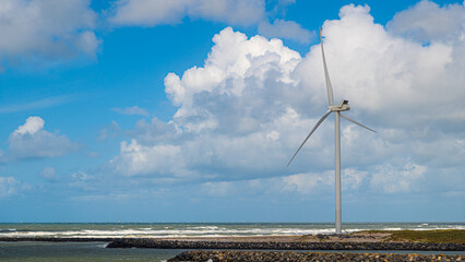 Windrad steht an der Küste in den Dünen und erzeugt Energie durch Wind