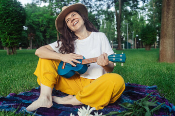 ukulele, learning to play ukulele, four-string instrument, relaxing on grass, playing in public, public park, musical therapy, psychology, meditation, relaxation, relaxation, happy, park, fun, outdoor