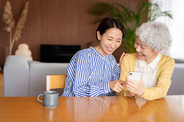 携帯電話の操作の仕方を娘に教わるシニア女性