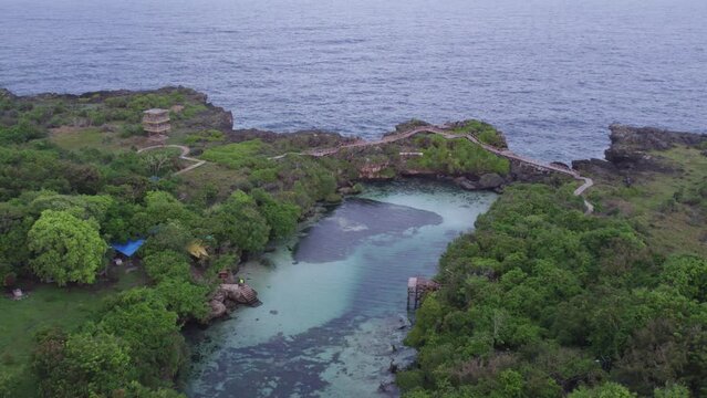 Flying backwards at Waikuri Lagoon Sumba with no people during sunrise, aerial