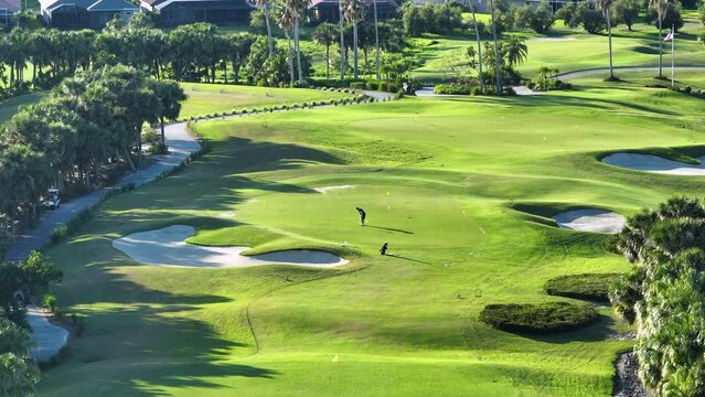 Active lifestyle of wealthy people. Aerial view of player practicing in golf on vast green golf course in sunny Florida. Active lifestyle of wealthy people