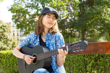 Young musician playing guitar in park