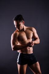 Fototapeta na wymiar Muscular and torso of young man having abs, bicep and chest. Male hunk with athletic body.