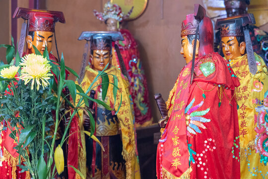 Human figures in traditional costumes in old Chinese Buddhist temple in Cholon or Chinatown  Ho Chi Minh City Vietnam