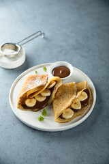 Homemade crepes with chocolate paste and banana